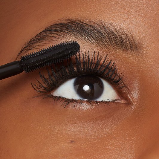 Close-up of Maybelline Lash Sensational Firework Washable mascara being applied with SuperSpark brush on upper lashes.