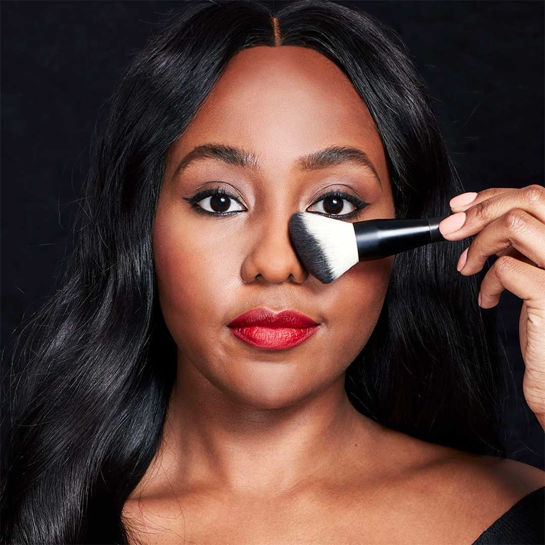 Model applying Lasting Fix Setting and Perfecting Loose Powder by Maybelline to nose.