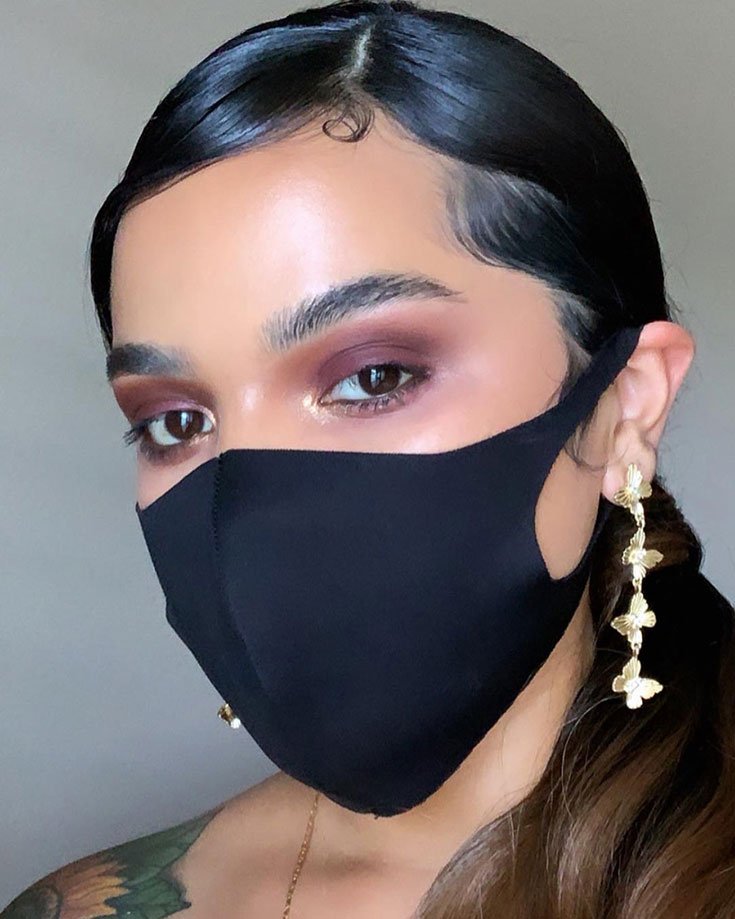 Model wearing a face mask and long lasting makeup by Maybelline.