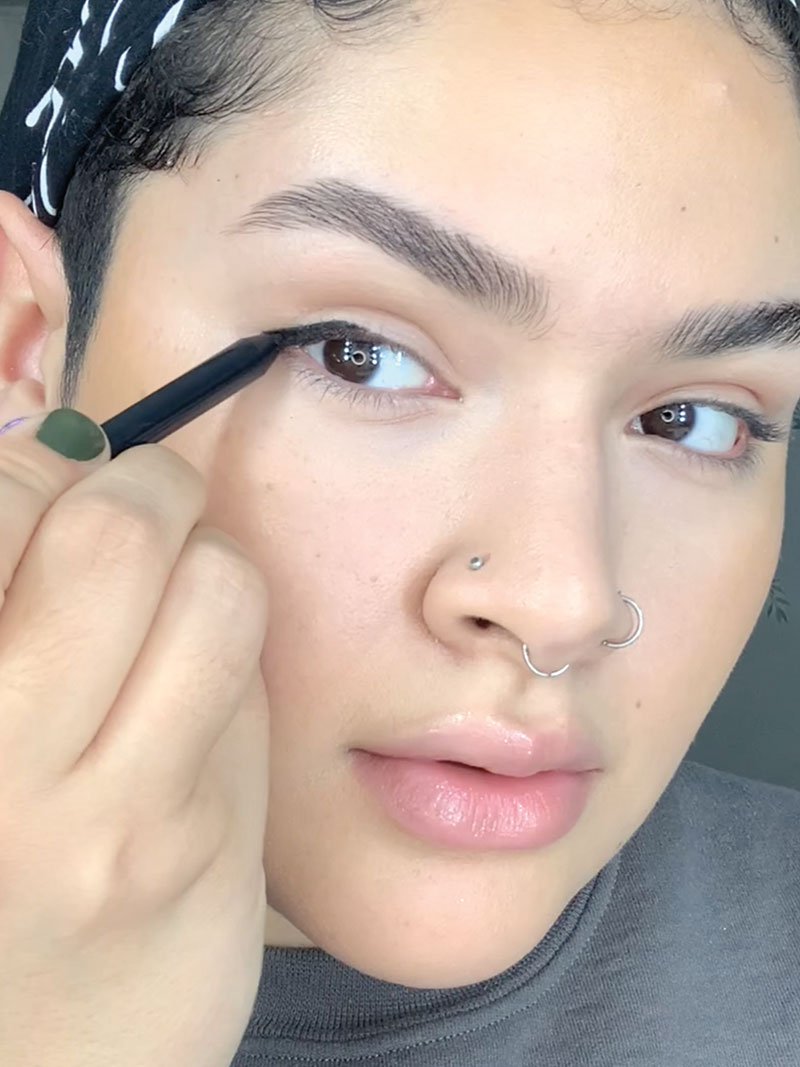 Karol shows how to do puppy eyeliner by applying black pencil eyeliner by Maybelline.