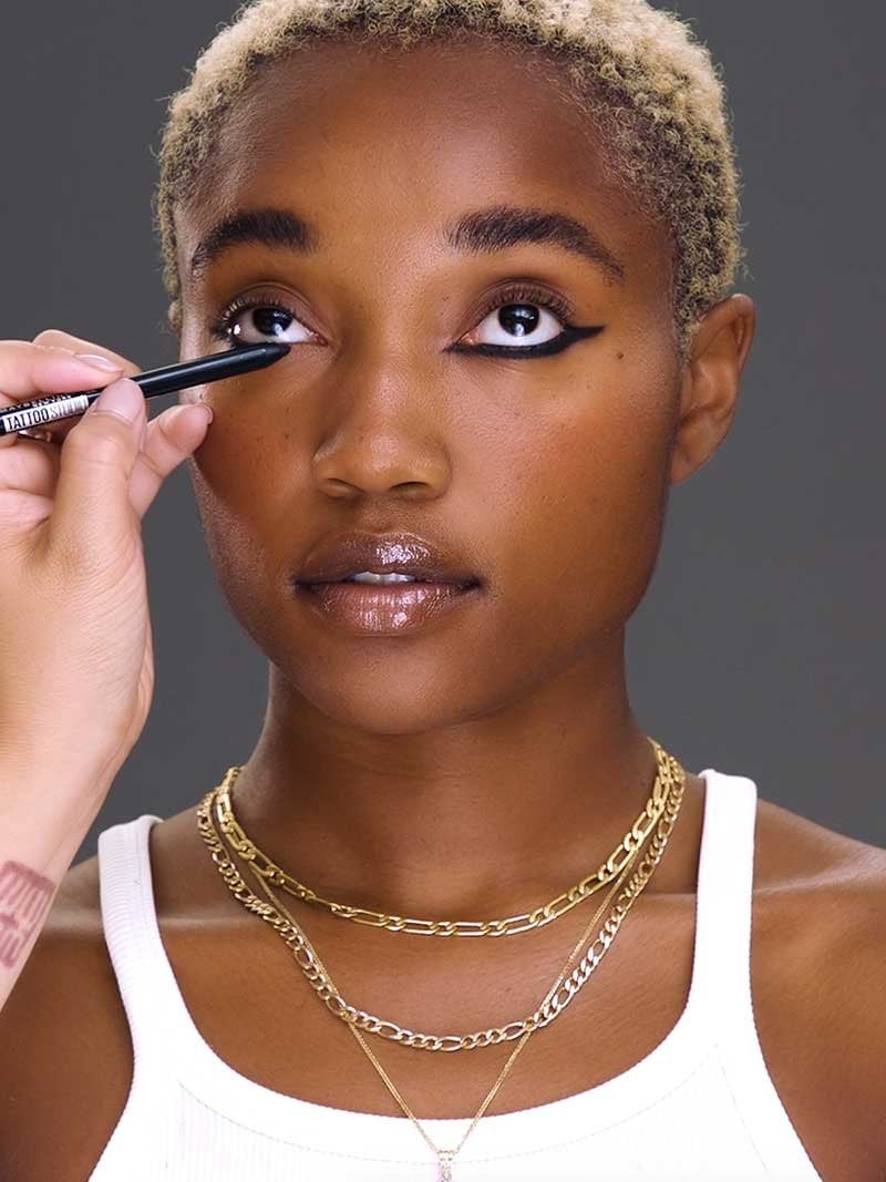 Makeup artists shows how to do reverse eyeliner by lining the lower lash line first.