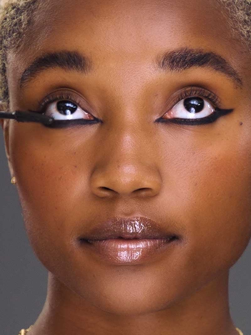 Makeup artists shows how to do reverse eyeliner by putting mascara on the lower eyelashes.